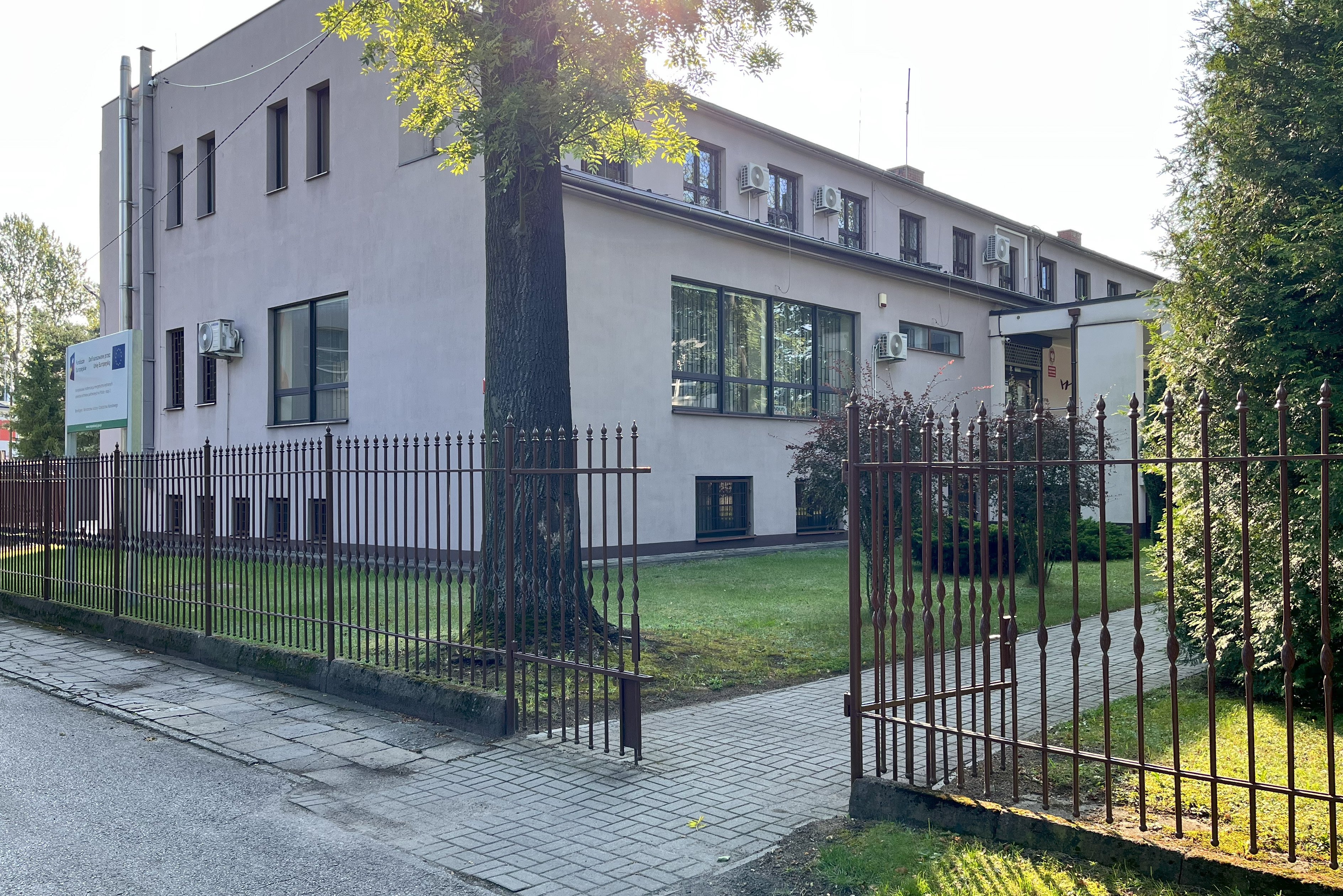 Widok otwartej furtki i budynku Archiwum Państwowego w Częstochowie.