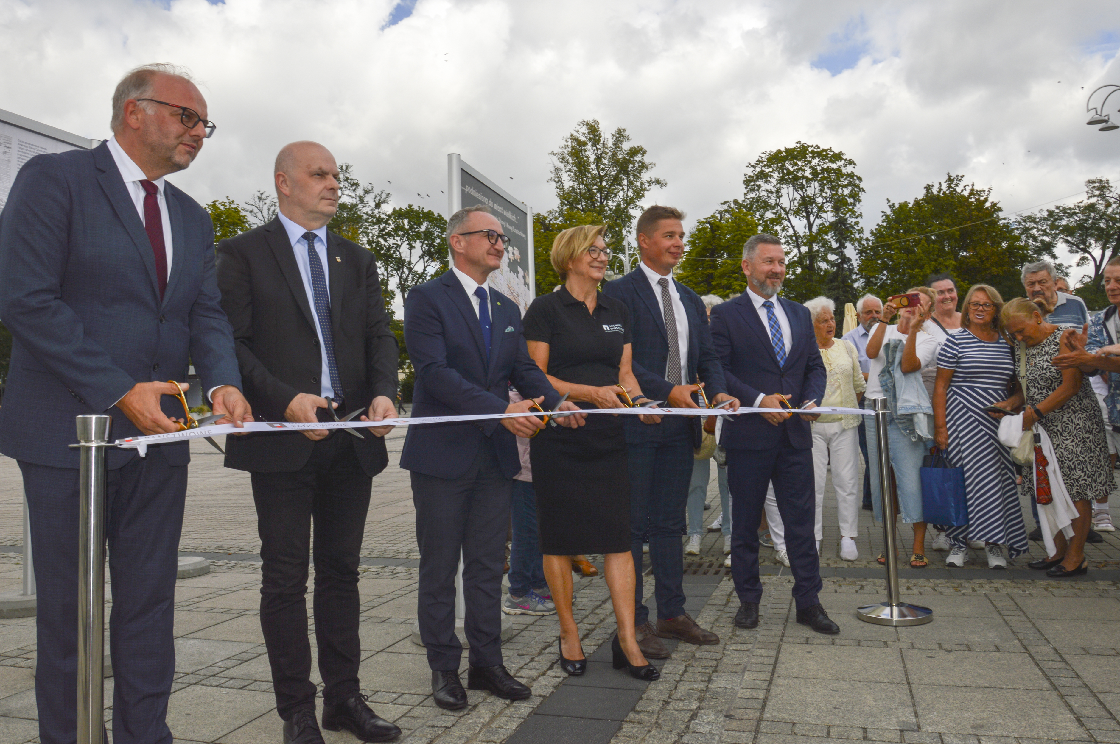 sześć osób przecina wstęgę nożyczkami