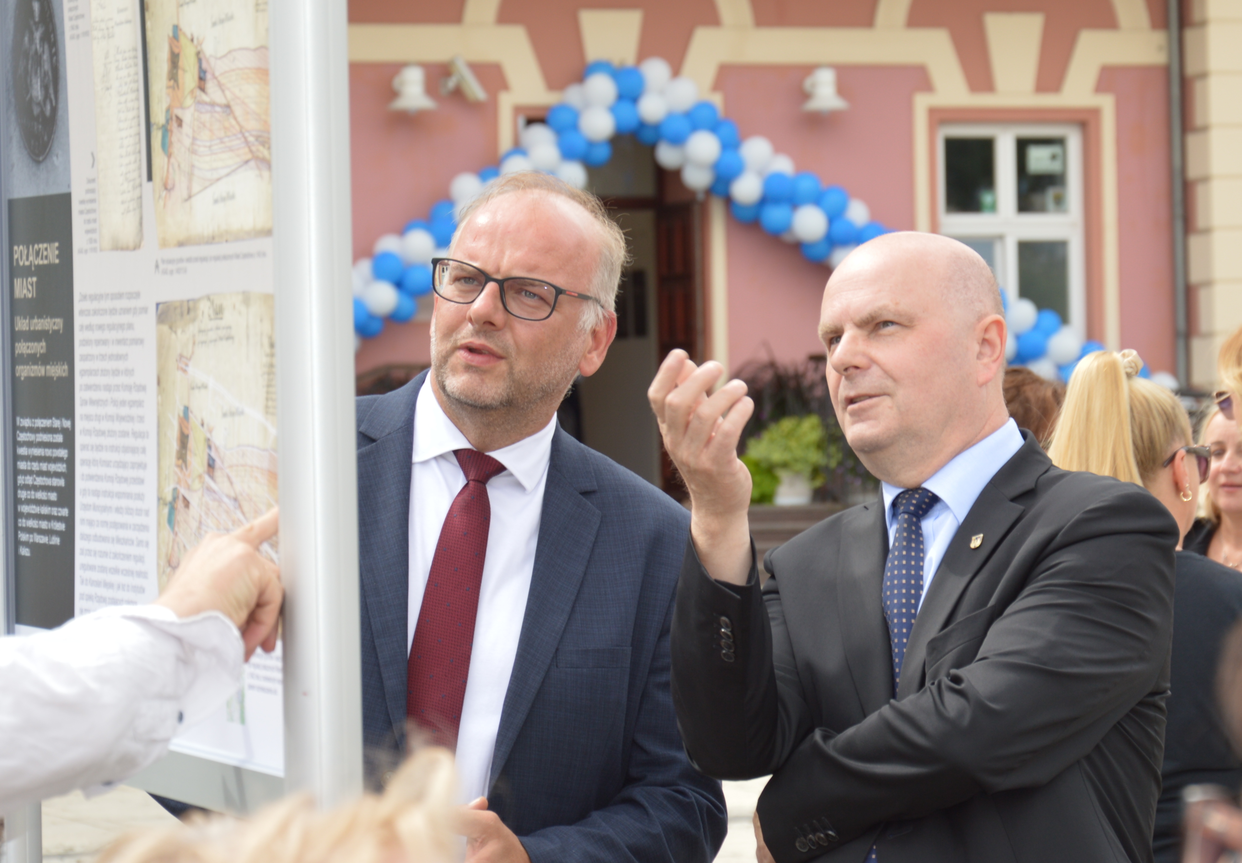 dwóch mężczyzn ogląda wystawę na planszy